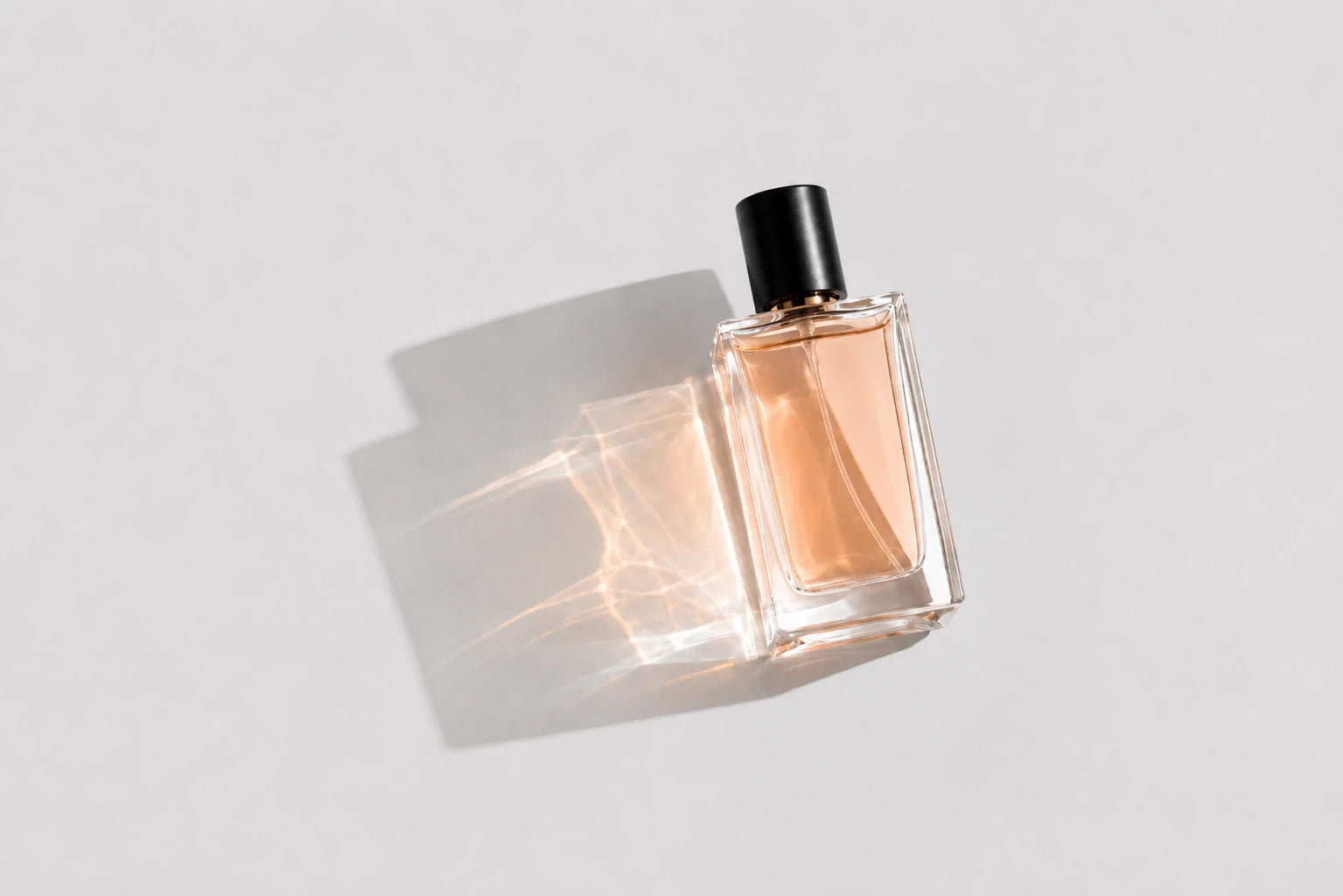 Damenparfum – eleganter roséfarbener Parfumflakon auf hellem Hintergrund