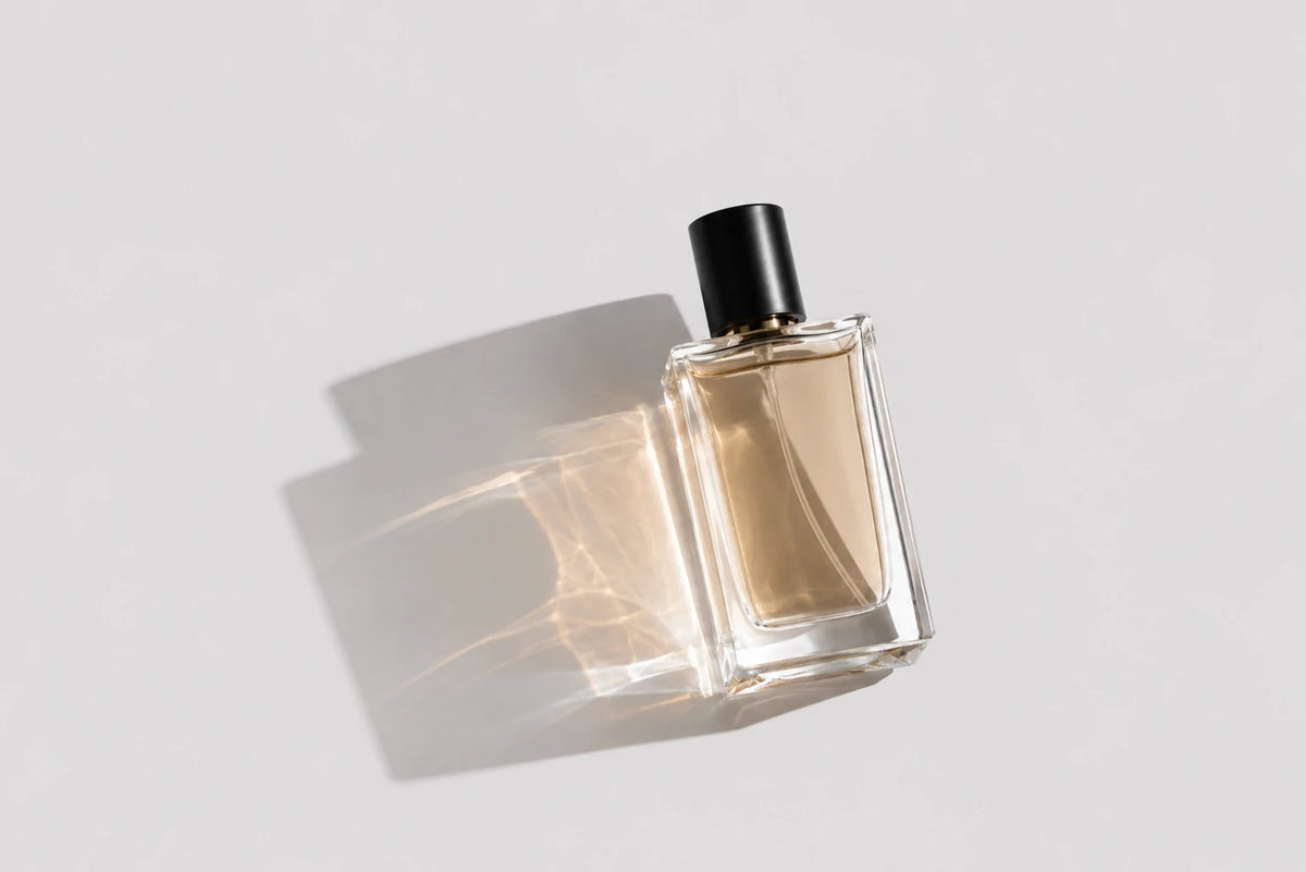 Herrenparfum – eleganter amberfarbener Parfumflakon auf hellem Hintergrund